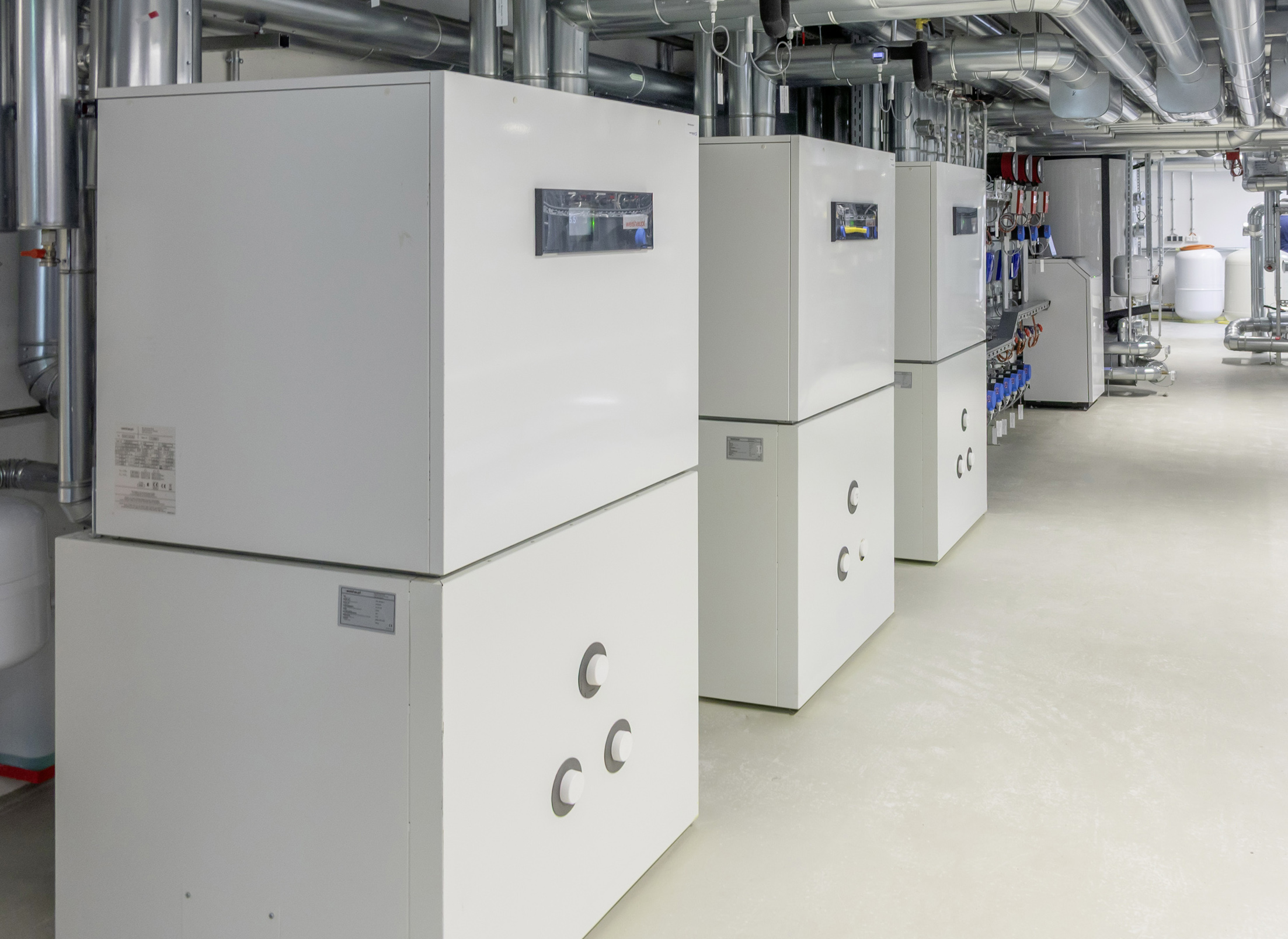 Beispiel: Das Hybridsystem in der Energiezentrale des Neubaus der Weishaupt Niederlassung Leipzig-Schkeuditz. Zwei Weishaupt Sole/Wasser-Wärmepumpen WWP S wandeln die Erdwärme in Heizenergie um.